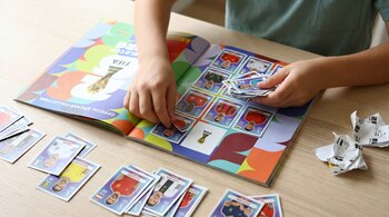 Niño pegando figuritas del Mundial 2026 en su álbum Panini